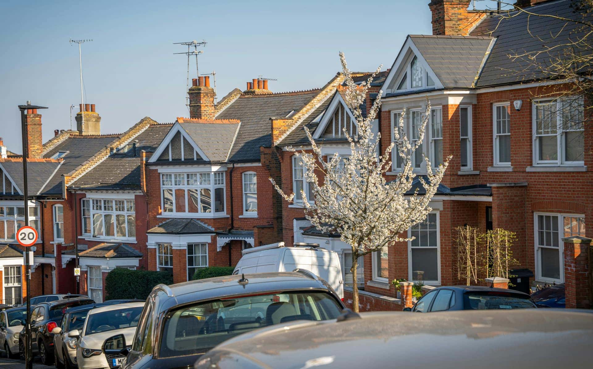 Red brick Edwardian terraced houses on a sunny street in London, England
